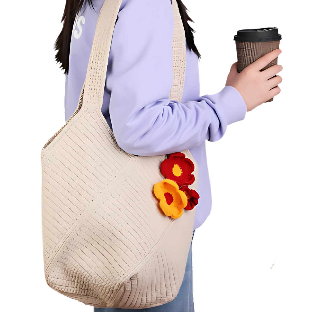 A person holds a coffee cup and carries the Bohemian Crochet Tote Bag, a large beige cotton yarn bag decorated with three colorful fabric flowers.