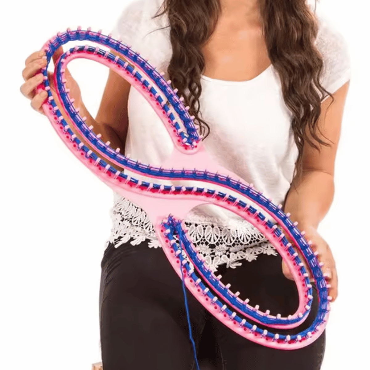A person holding the Knitting Loom for Blankets and Scarves—a large, pink, figure-eight tool with blue pegs and yarn—ideal for beginners making cozy blankets.