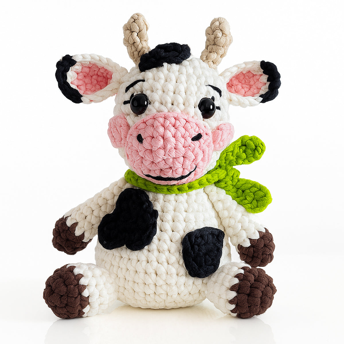 Create your own plush amigurumi cow with Hazel The Cow Crochet Pattern—features black spots, pink snout, and a green scarf. Ideal for advanced beginner crocheters or anyone seeking a cute crochet cow project.