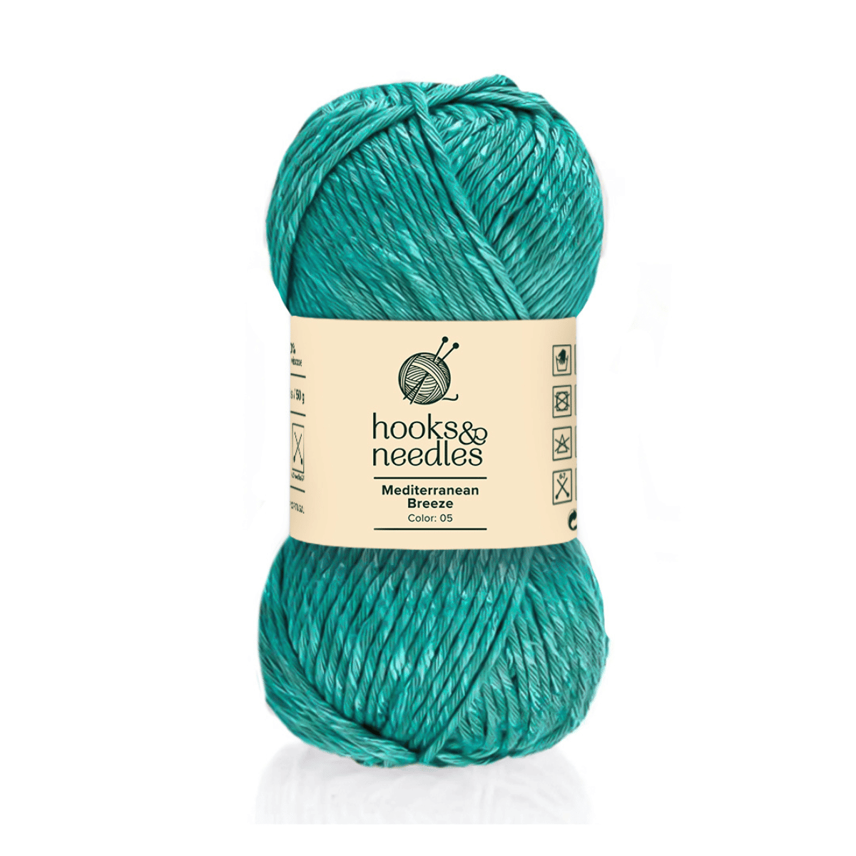 A skein of Mediterranean Breeze in teal (Color: 05) by Hooks & Needles has care symbols on its packaging. This bulky-weight cotton-viscose yarn is ideal for cozy projects.