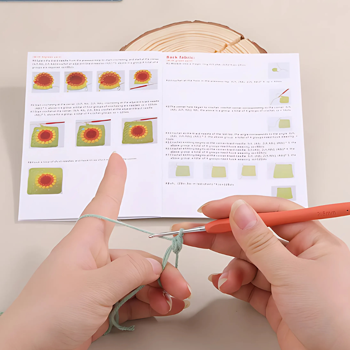 Using a Crochet Bag Kit, someone crafts a sunflower bag from green yarn with a crochet hook, following illustrated step-by-step instructions in an open pattern booklet on the tabletop.