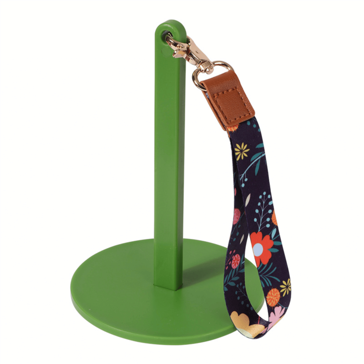 The Wrist Yarn Holder features a green metal stand with a circular base, displaying a keychain with a floral fabric strap and leather accent—ideal for travel crafting or hands-free yarn control in style.