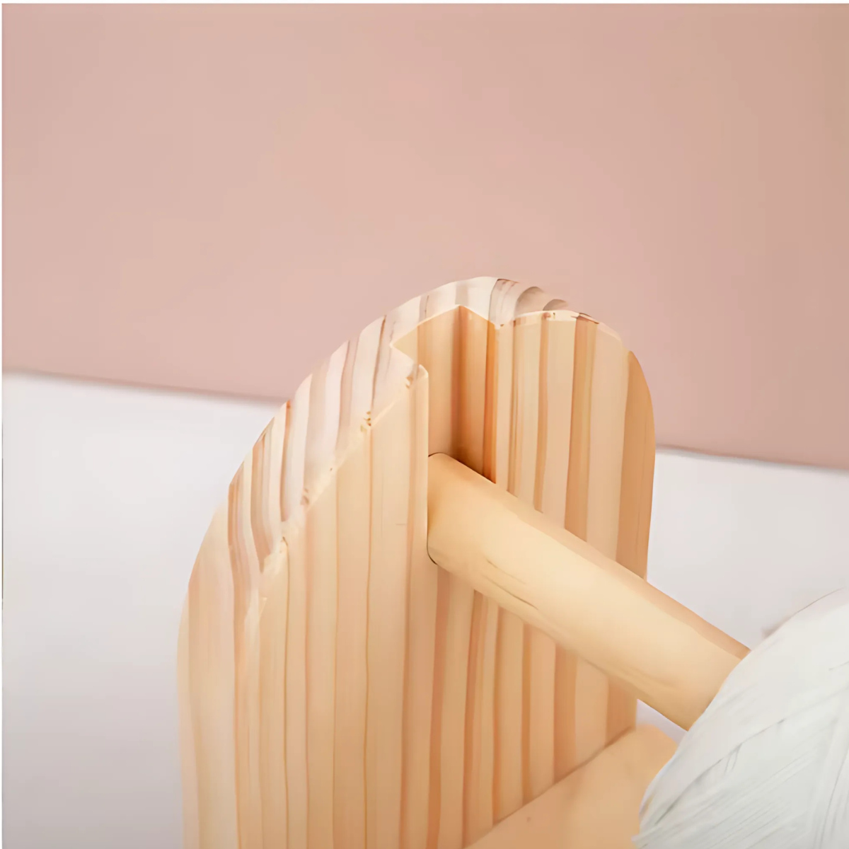 Close-up of the Wooden Yarn Dispenser featuring a rounded, ribbed panel and a cylindrical rod fitted in a slot for smooth rotation, set against a neutral background—a true display of fine craftsmanship.
