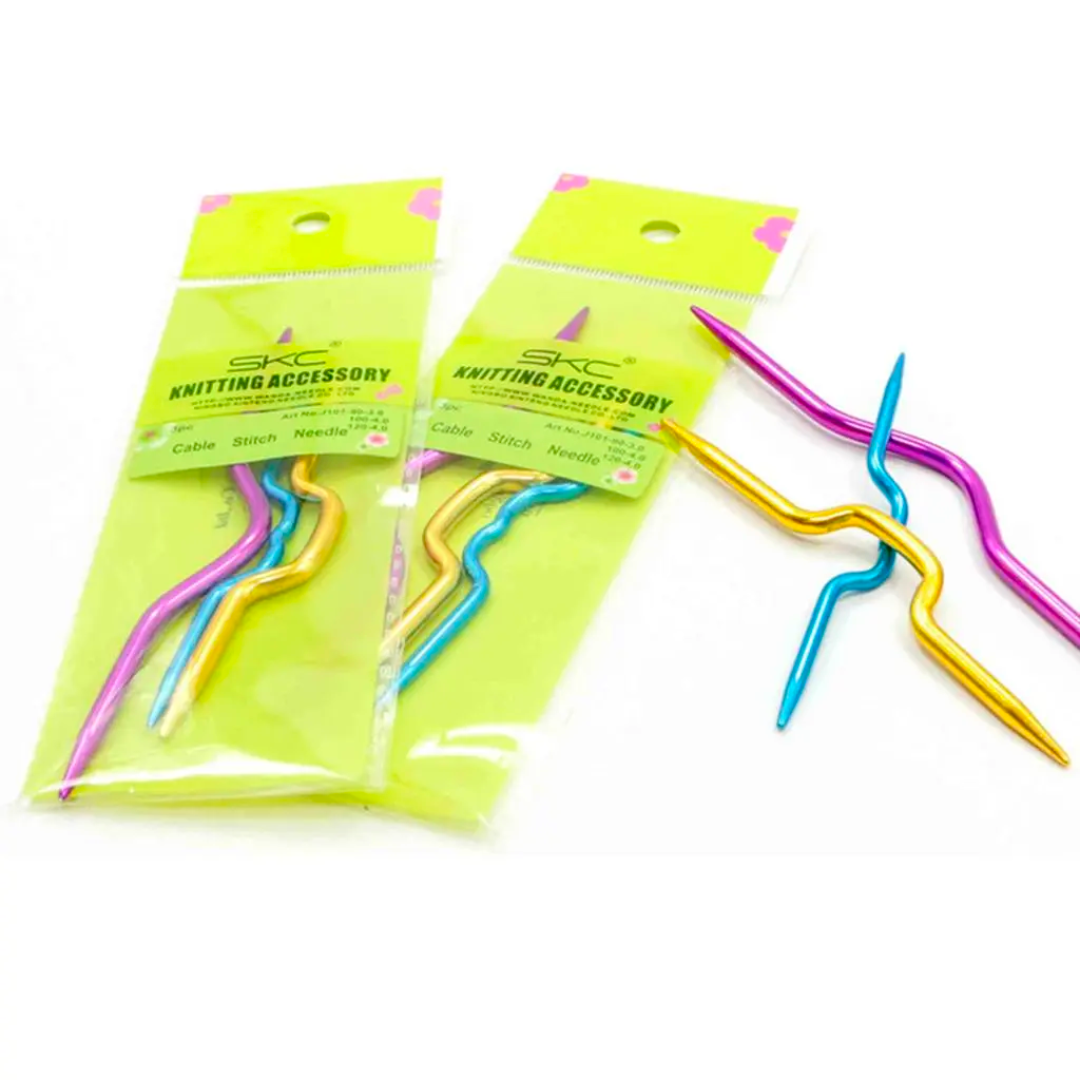 Two packs of Aluminum Cable Needles are displayed, with one pack open to showcase the vibrant pink, gold, and blue needles arranged diagonally. Ideal for cable knitting projects that require both precision and style.