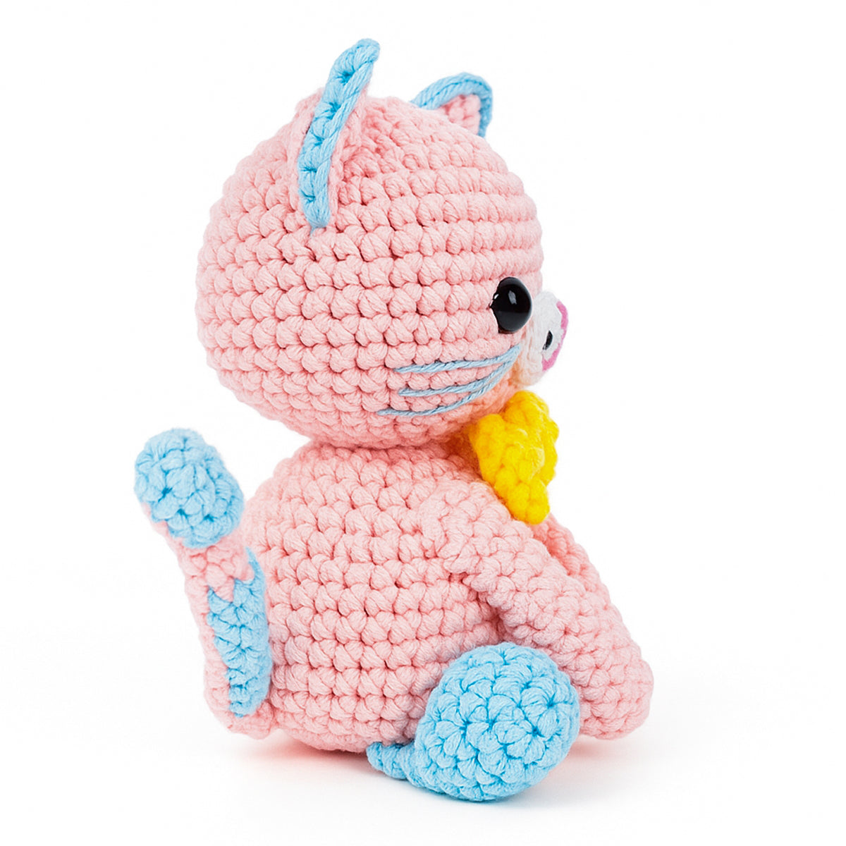 Luna The Cat is a crocheted pink amigurumi plush toy with blue accents and a yellow bow, sitting upright and facing sideways—an adorable intermediate crochet project perfect for cat lovers.