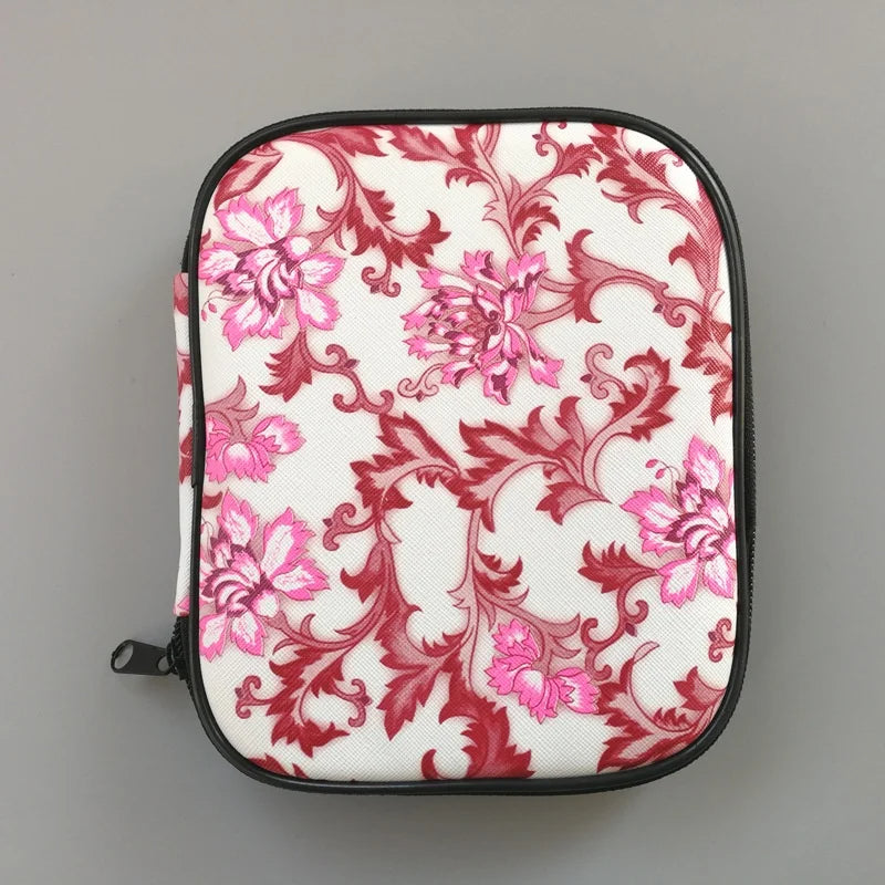 A compact square zippered case that showcases an artistic floral design in red and pink hues on a white background.
