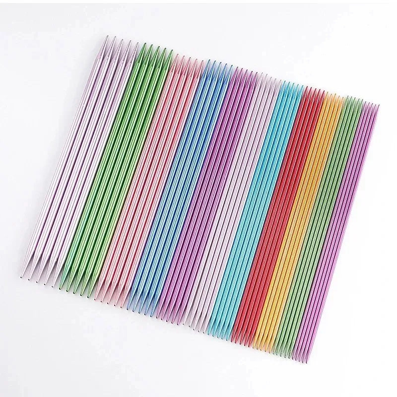A neatly arranged set of colorful aluminum knitting needles, laid out in parallel rows on a white surface, showcases the elegance of the 55 Pcs Double Pointed Knitting Needle Set.