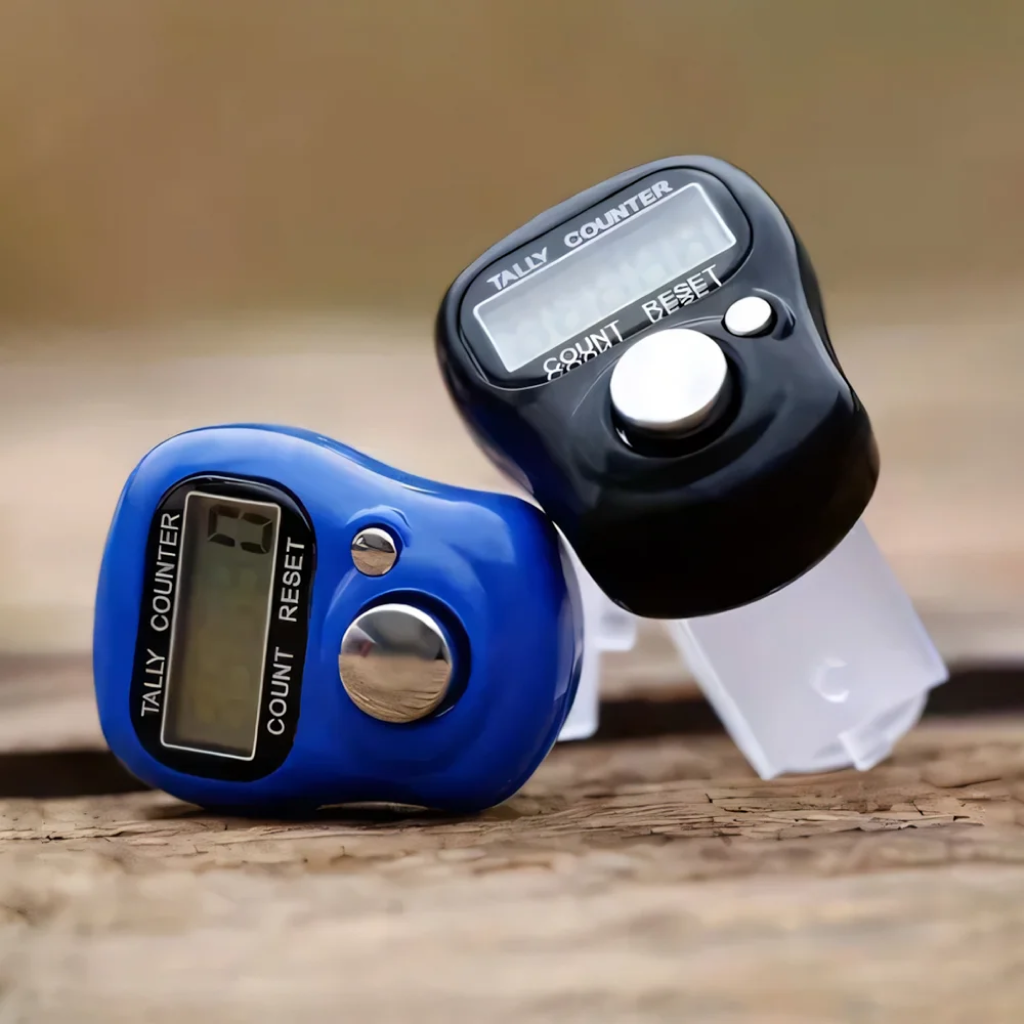 Two Digital Row Counters, one blue and one black, sit on a wooden surface. Each features a display screen and "Count" and "Reset" buttons for easy one-click counting—ideal as crafting accessories or row counters.
