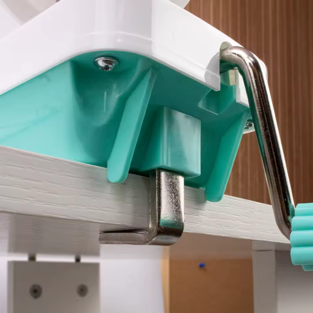 A metal clamp secures the Yarn Ball Winder to a wooden table, providing time-saving convenience for making uniform yarn balls.