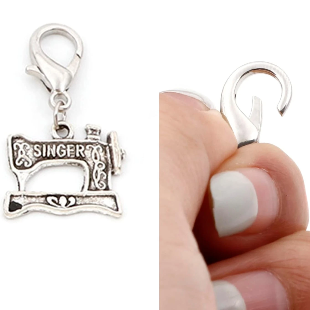 Set of 12 durable steel Stitch Markers with lobster clasps and silver Singer sewing machine charms; close-up shows a hand opening the clasp—perfect as unique knitting accessories.
