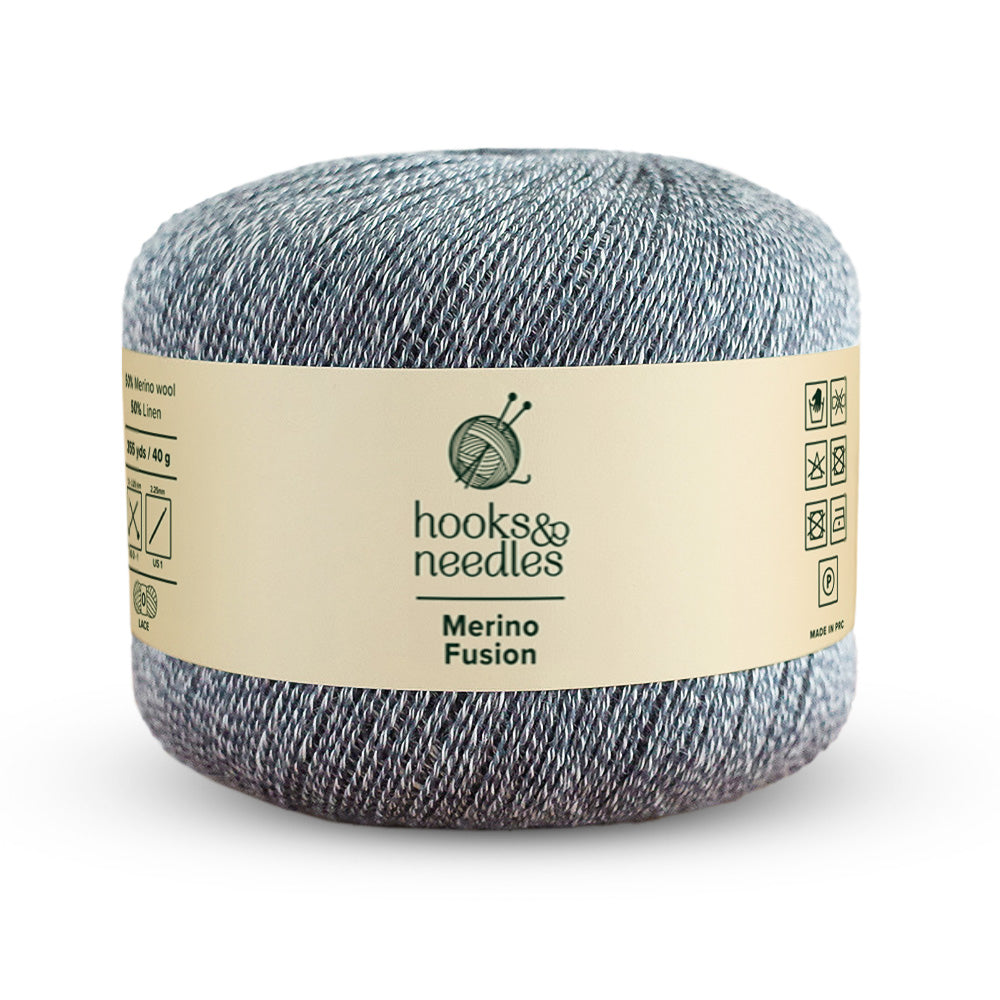 A ball of Merino Fusion Yarn 40g in a gray shade, made from premium merino wool, featuring "hooks & needles" branding and care symbols on the label.
