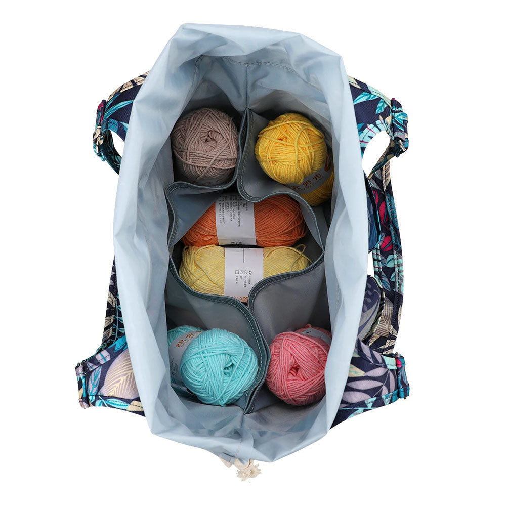 Top view of the "Yarn Tote Bag: Knit on The Go (bundle)" showcasing seven vibrant balls of yarn neatly organized in separate compartments, featuring a floral patterned exterior—an ideal accessory for knitters.