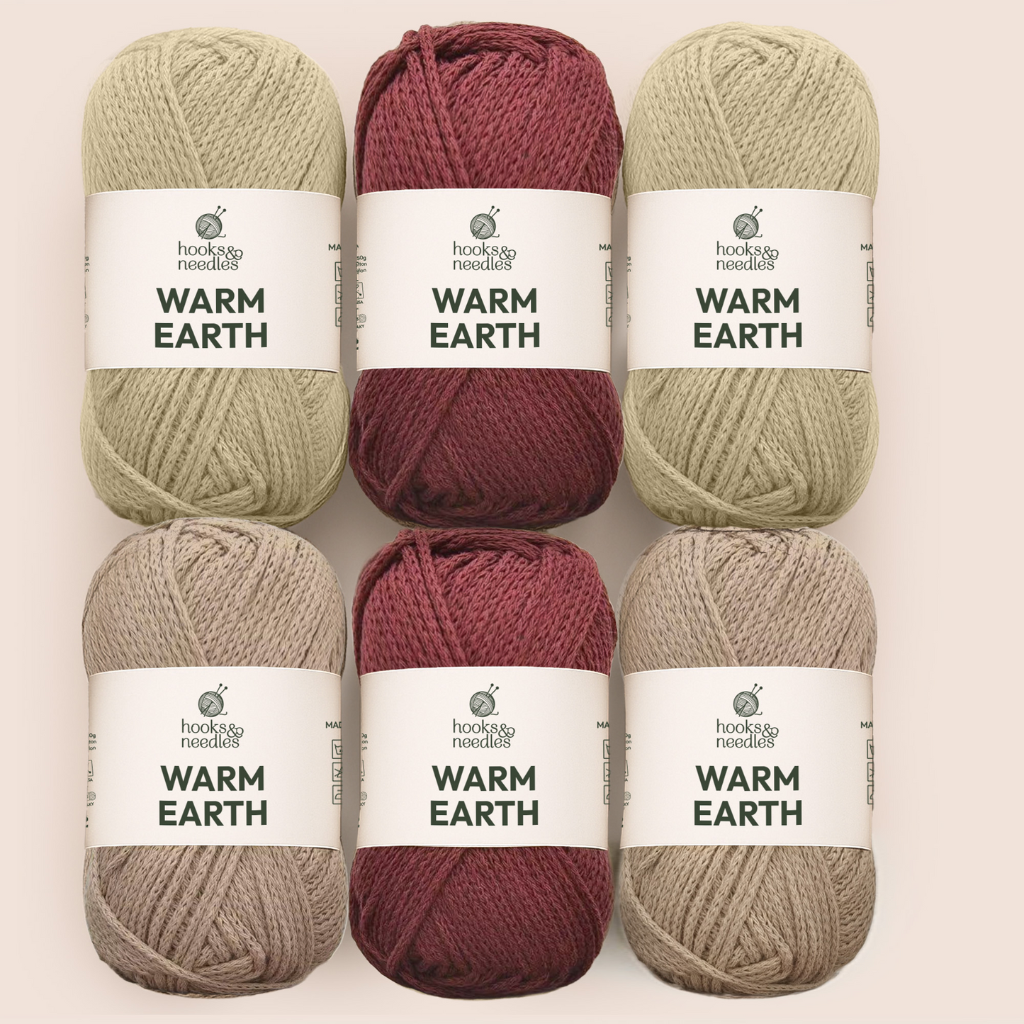 Six skeins from the Hooks & Needles Yarn Subscription Box in beige, maroon, and taupe are arranged in two rows of three, each featuring a white label with the Hooks & Needles brand.