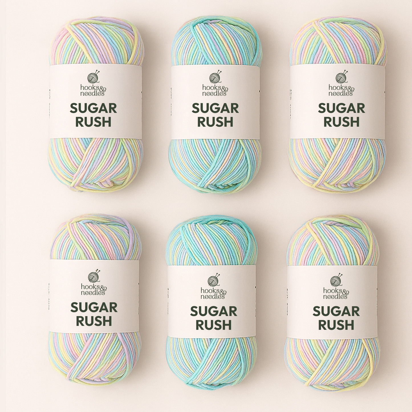 Six skeins of pastel multicolored yarn from the Hooks & Needles Yarn Subscription Box are arranged in two rows of three on a light background.