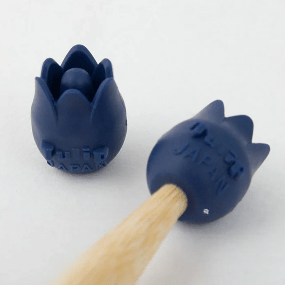 Two Tulip Rubber Point Protectors Large in blue, designed with a flower shape and featuring a durable, anti-slip rubber material with "JAPAN" embossed on them, are snugly fitted onto the ends of wooden pencils.