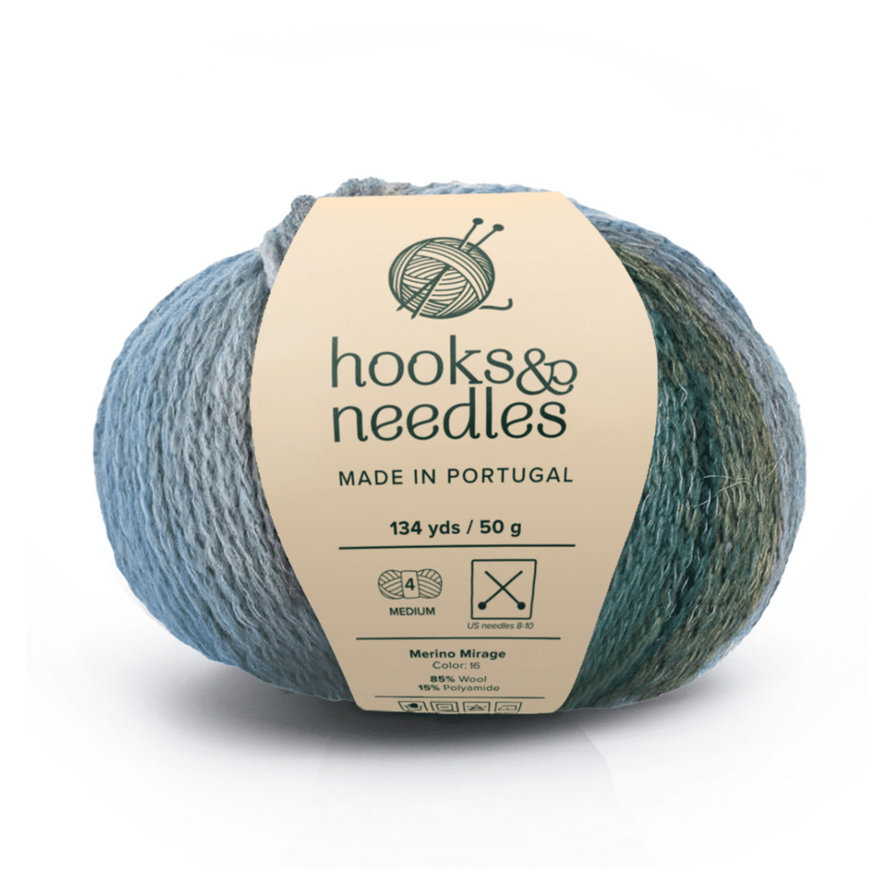 A 50g, 134-yard ball of Merino Mirage luxury yarn (85% Merino wool, polyamide) in blue-green variegated "Mirage" color, labeled hooks & needles, made in Portugal.