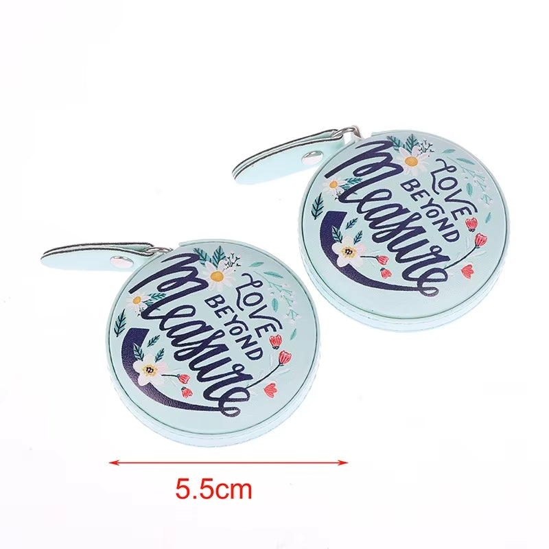 Pair of light blue round pouches featuring "Love Beyond Measure" text and a floral design, complete with zippers, ideal for organizing your knitting and crocheting essentials. Size precisely measured at 5.5 cm.