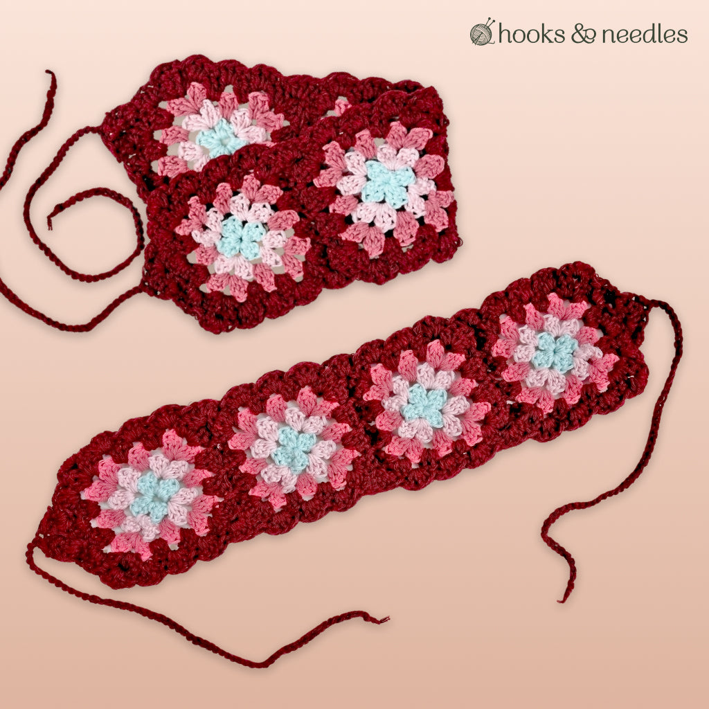 Three crocheted granny square strips with red, pink, and light blue motifs are displayed on a light pink surface. The Hooks & Needles logo appears in the corner. This is perfect for making the Vintage Headband Crochet Pattern.