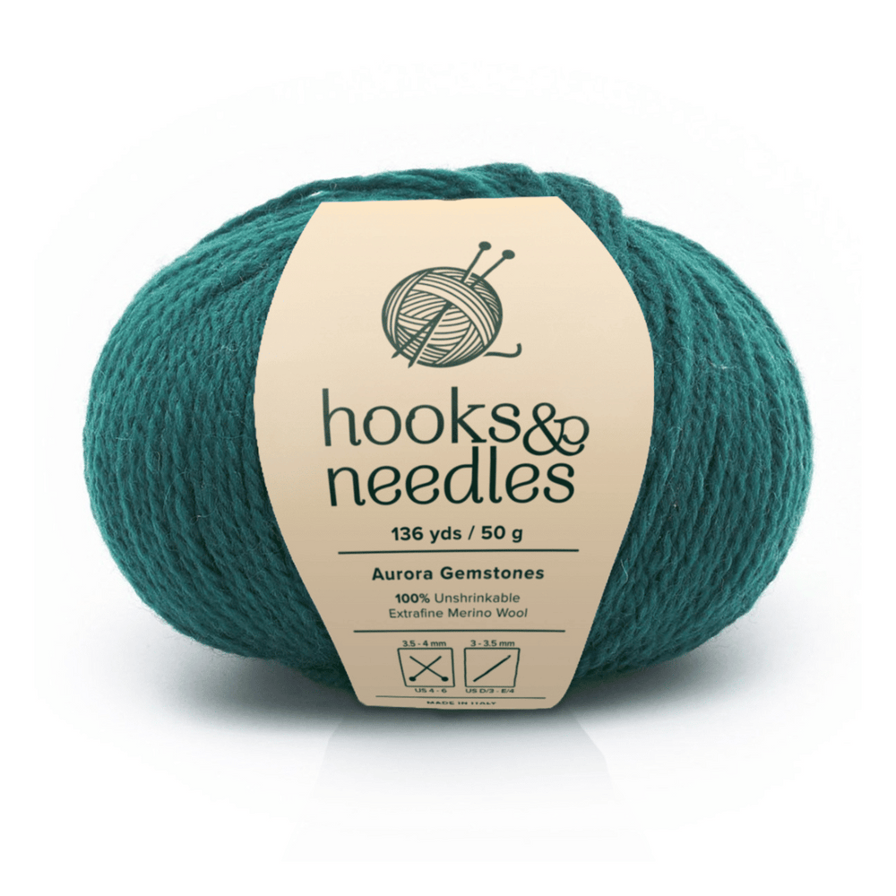 Aurora Gemstones Pear Frost Yarn, labeled "hooks & needles," 136 yds/50g—crafted from 100% unshrinkable merino wool, perfect for lightweight projects. Care instructions included on the label.