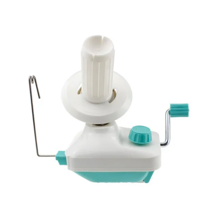 The white and teal kitchen tool is manually operated with a hand crank, similar in design to the Yarn Ball Winder, making it ideal for peeling and coring fruits or vegetables.