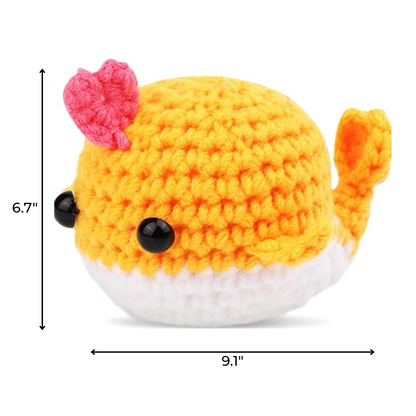 The Crochet Whale Kit 2pcs includes yellow and white whale plush toys, each with a pink heart on its head, black eyes, and measuring 6.7 inches tall by 9.1 inches wide.