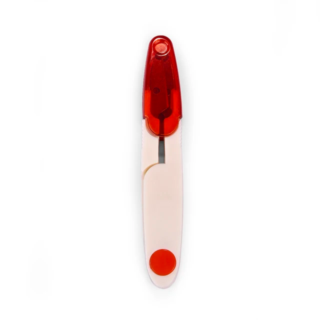 A red and white Yarn Thread Snips, encased in a protective cover, showing a positive result.