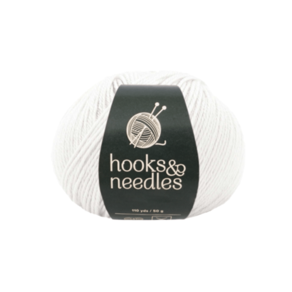 The Fuzzy Whirl Yarn 100g, featuring a classic white design and "hooks & needles" label, provides the ideal texture and durability for your next project.