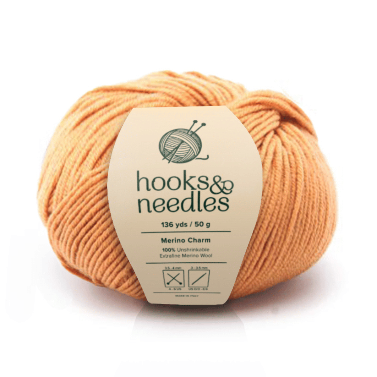 A skein of Merino Charm Yarn 50g in orange (136 yds, 100% extrafine merino wool) features washing, ironing, and drying icons—an unshrinkable yarn combining softness with durability.