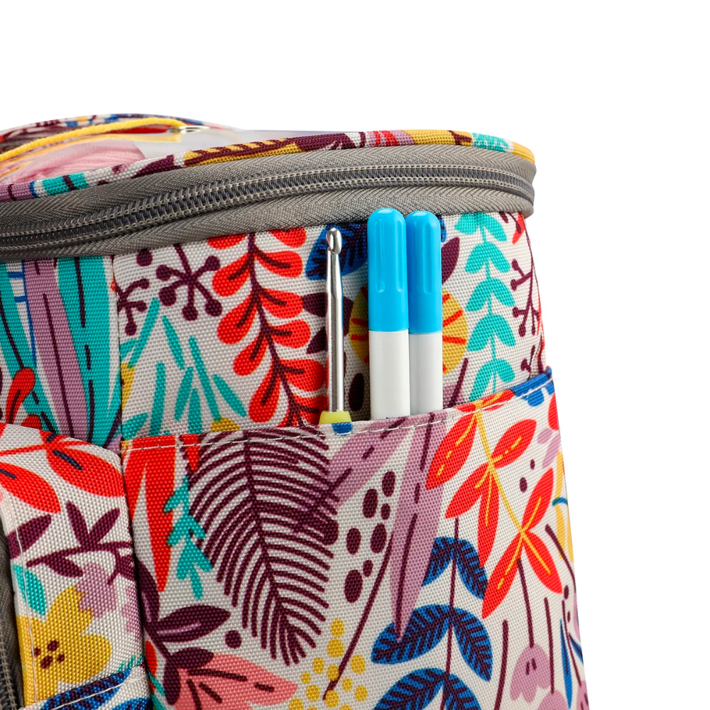 Close-up of the Crochet Knitting Bag Organizer (Bundle8), adorned with a vibrant floral pattern and featuring a gray zipper. Two blue pens are visible in the front pocket, illustrating additional storage for knitting accessories and crafting supplies.