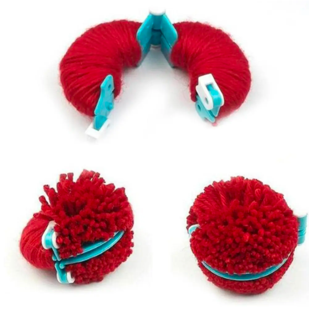 A durable red Pom Pom Maker Set with partially completed pom-poms at different stages of completion.