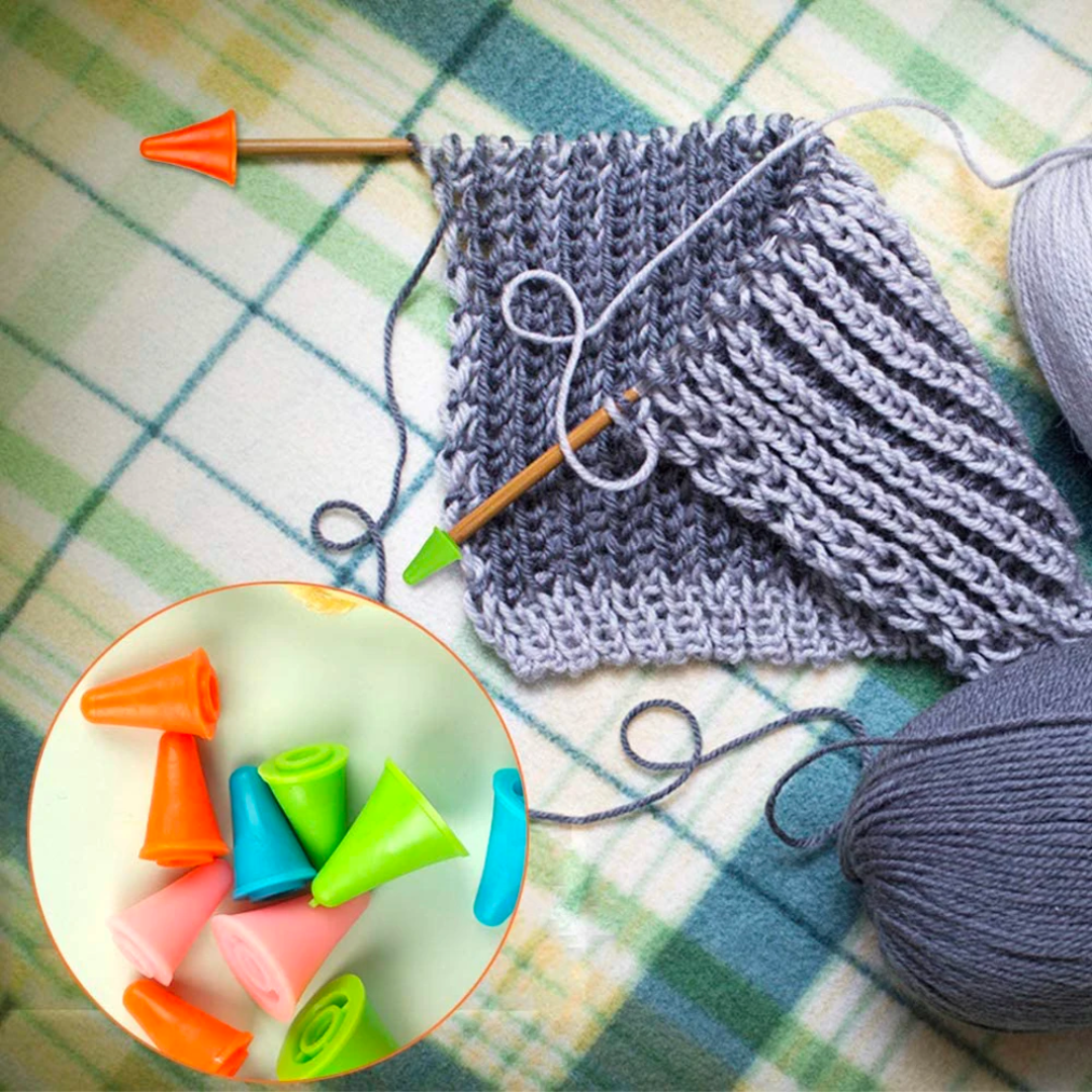 A knitting project unfolds on plaid fabric with gray yarn, needles, and a close-up of multi-colored needle caps, enhanced by the Knitting Needles Point Protectors 25pcs for added safety.