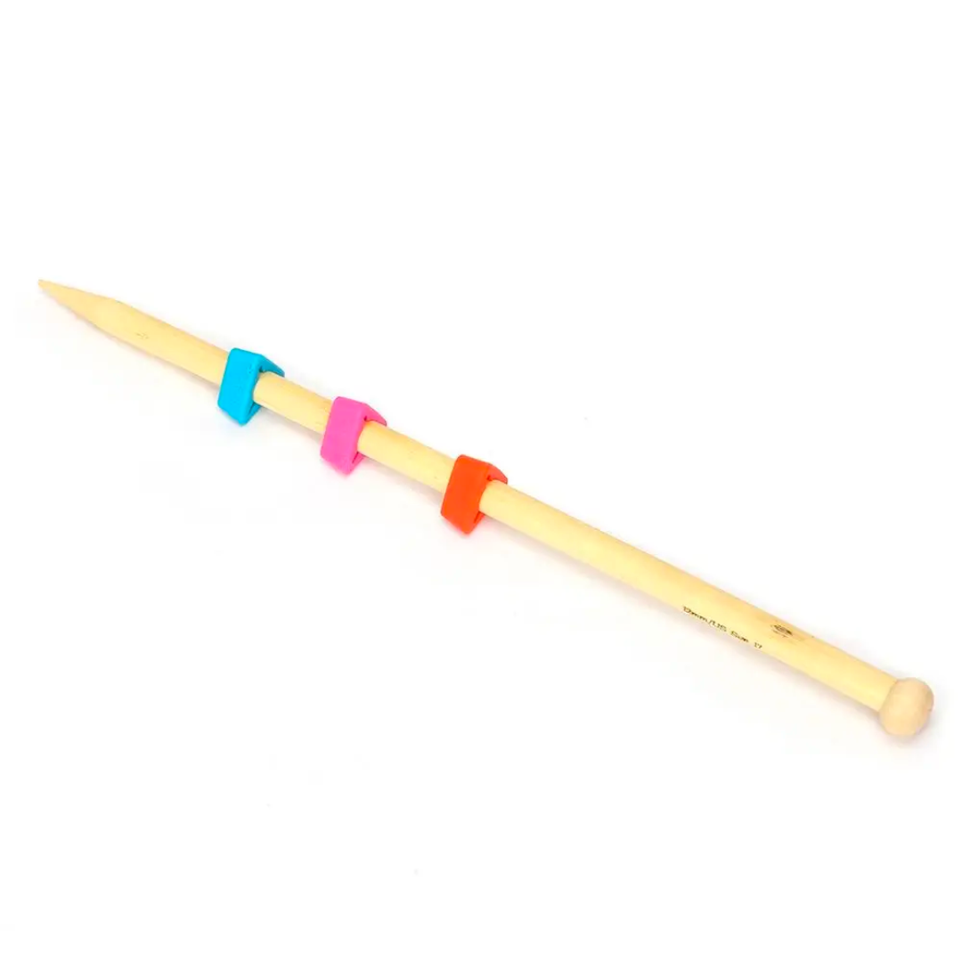 Wooden knitting needles with Knitting Needles Tip Protectors 18pcs wrapped around them on a white background.