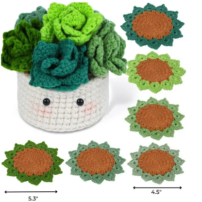 The Plant Pot Crochet Kit with Coasters features a white crocheted pot with a smiling face and green crochet succulents, plus seven 4.5" green and brown coasters for handmade home decor.