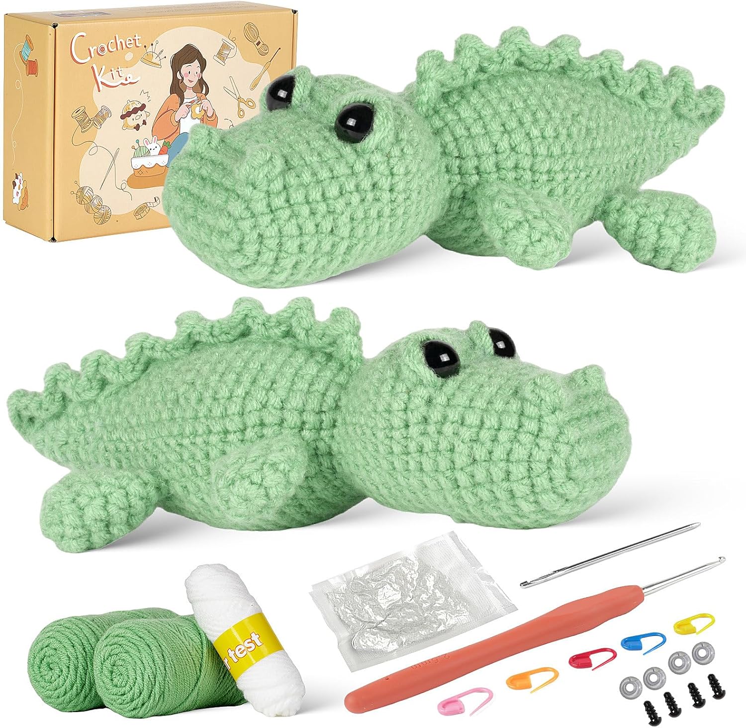 The Crochet Crocodile Kit 2pcs includes a box, two green crocheted crocodiles, yarn, crochet hooks, stuffing, stitch markers, safety eyes, and other tools—ideal for beginner crochet projects.