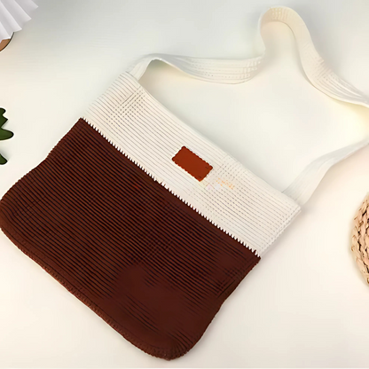 The Modern Crochet Tote Bag Kit features a stylish two-tone design with a white cotton yarn strap and upper section, and a brown lower section, shown lying flat on a white surface.