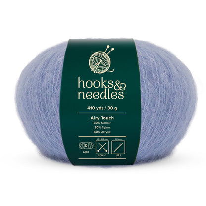 A skein of light blue "Airy Touch Yarn 30g" by hooks&needles, perfect for creating delicate accessories. Composed of 30% mohair, 30% nylon, and 40% acrylic, it weighs 30 grams and offers an ethereal stretch of 410 yards.