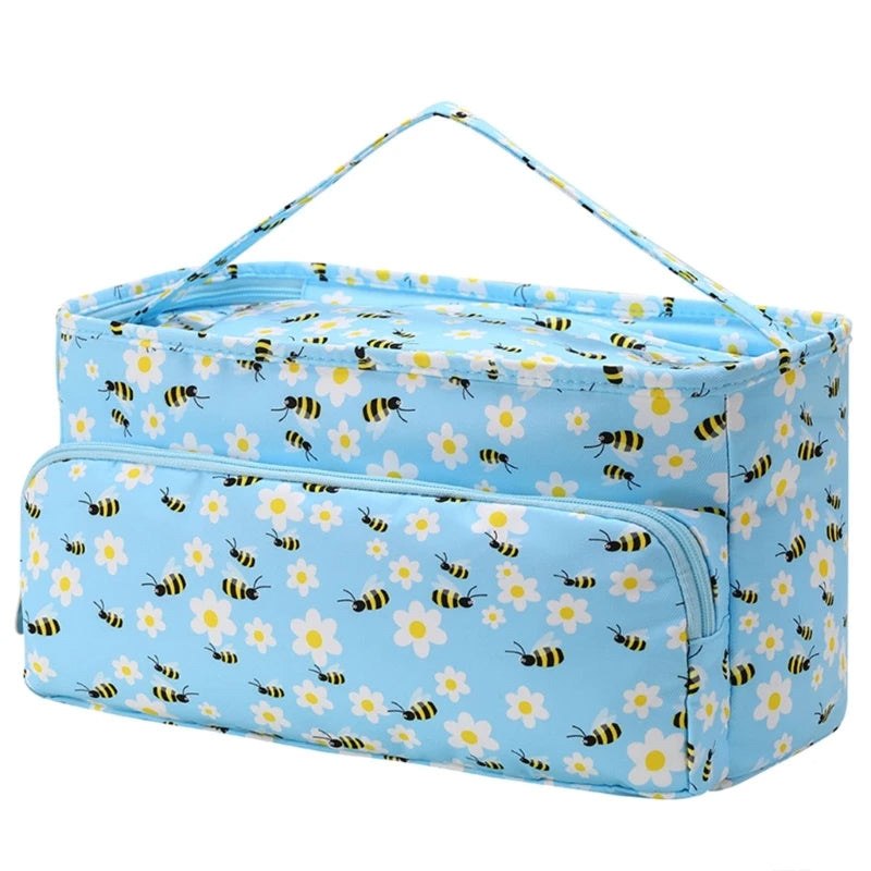 A blue rectangular Knitting Bag: Yarn Storage Organizer with a floral and bee pattern, perfect for crochet enthusiasts. It features a handle on top, an external zippered pocket, and is ideal as a yarn storage organizer.