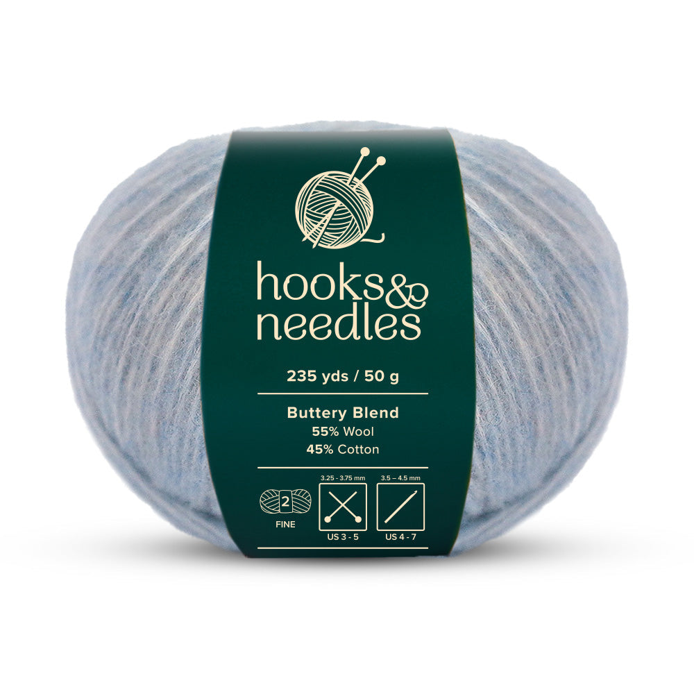 Introducing the Buttery Blend Yarn 50g by Hooks & Needles, this fine-weight yarn offers 235 yards per 50-gram ball. Composed of a soothing light blue blend of 55% wool and 45% cotton, it's an excellent choice for your crafting needs.