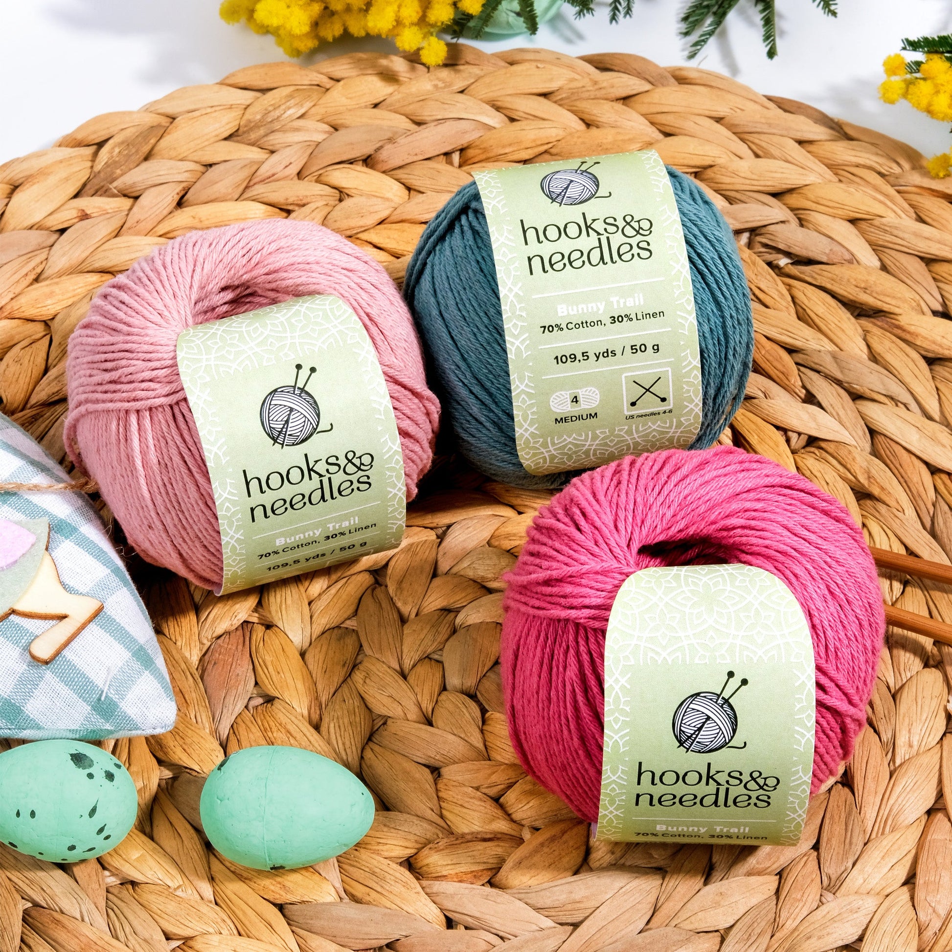 Four skeins of Limited Edition Easter Special Collection (bundle) yarn, displayed on a woven mat with a floral accent and pastel Easter eggs.