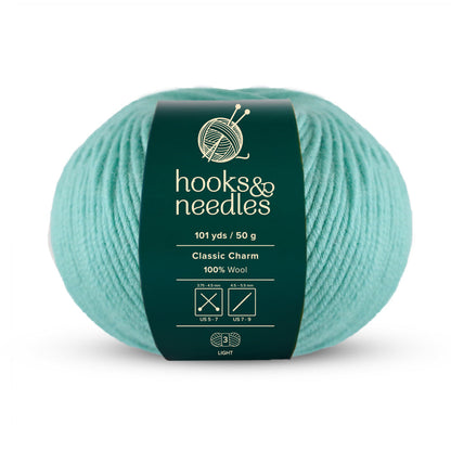 The "Classic Charm Yarn 50g" in teal is a delightful ball of yarn branded as "hooks & needles," made entirely of wool, offering 101 yards of light-weight enjoyment.