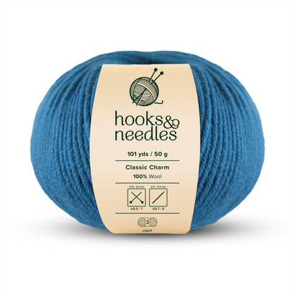 A skein of blue "Classic Charm Yarn 50g," made entirely of wool, exudes classic charm with its lightweight nature at 50 grams and stretches across 101 yards.