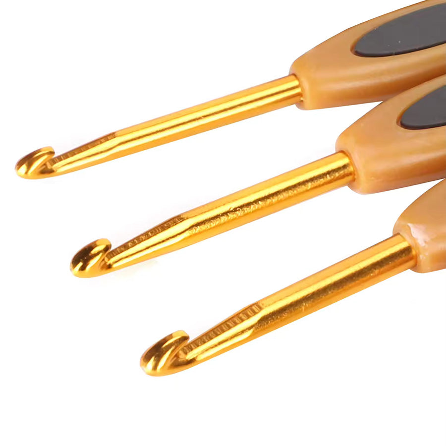 Close-up view of a high-quality design featuring three gold-colored ergonomic crochet hooks with comfortable handles arranged horizontally from the Crochet Hook Set 8 Pcs.