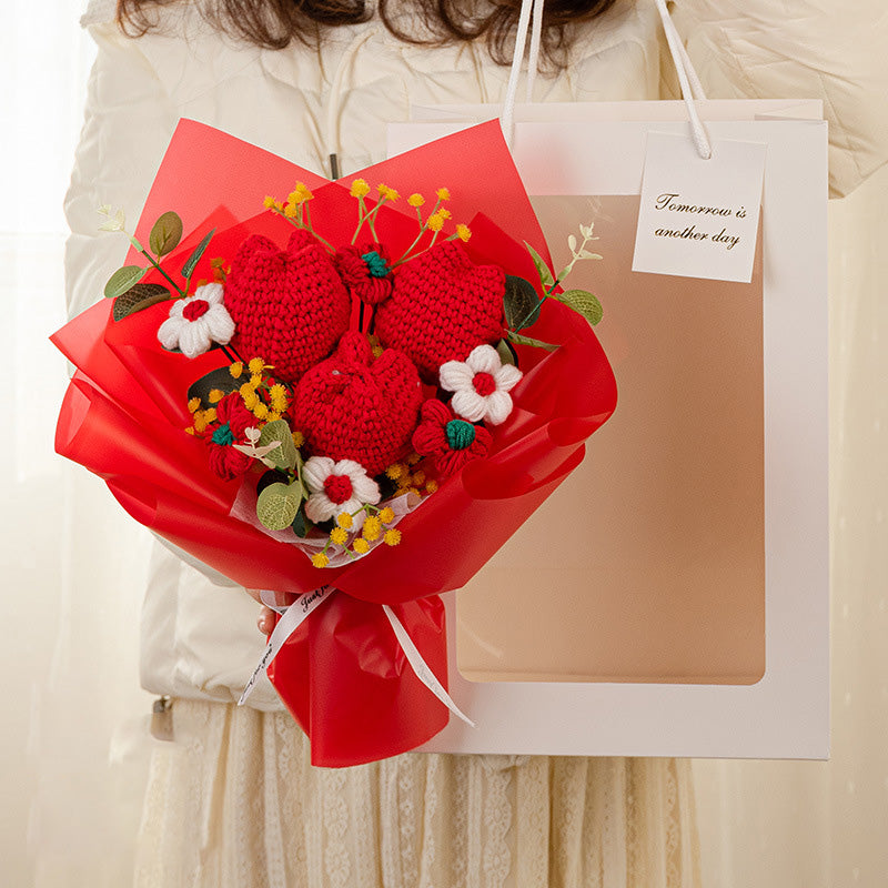 A person holds a large paper gift bag and a handcrafted floral arrangement called the "Crochet Tulip Bouquet: Springtime in Every Stitch," featuring red flowers with green leaves. A small card attached to the bag reads "Tomorrow is another day.