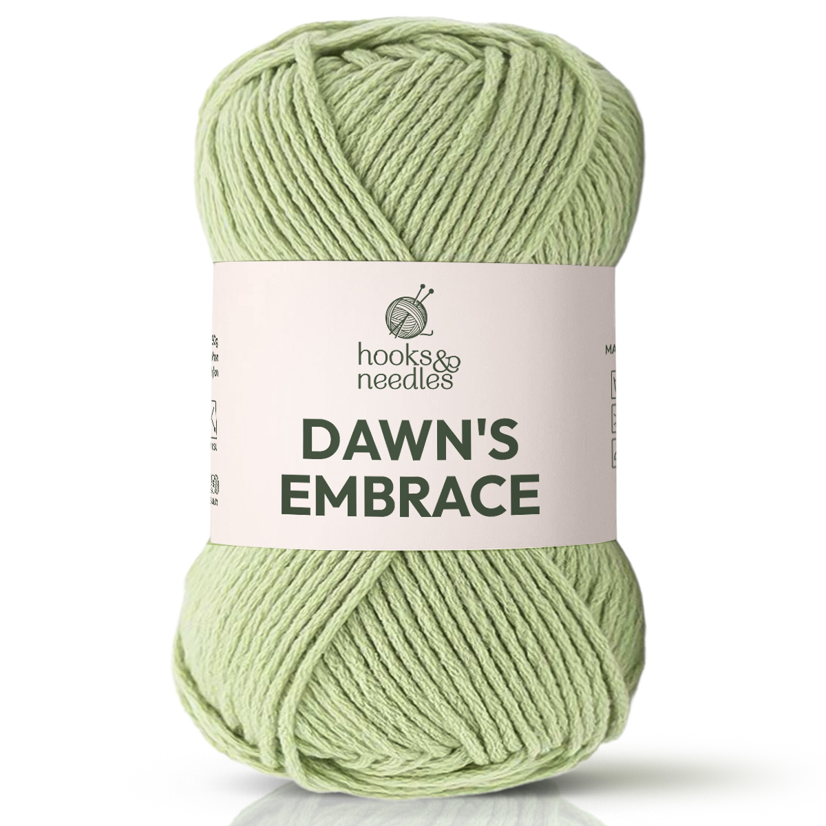 A skein of Dawn's Embrace Yarn in light green, bulky weight, featuring knitting needle and yarn graphics on the label—ideal for cozy blanket projects.