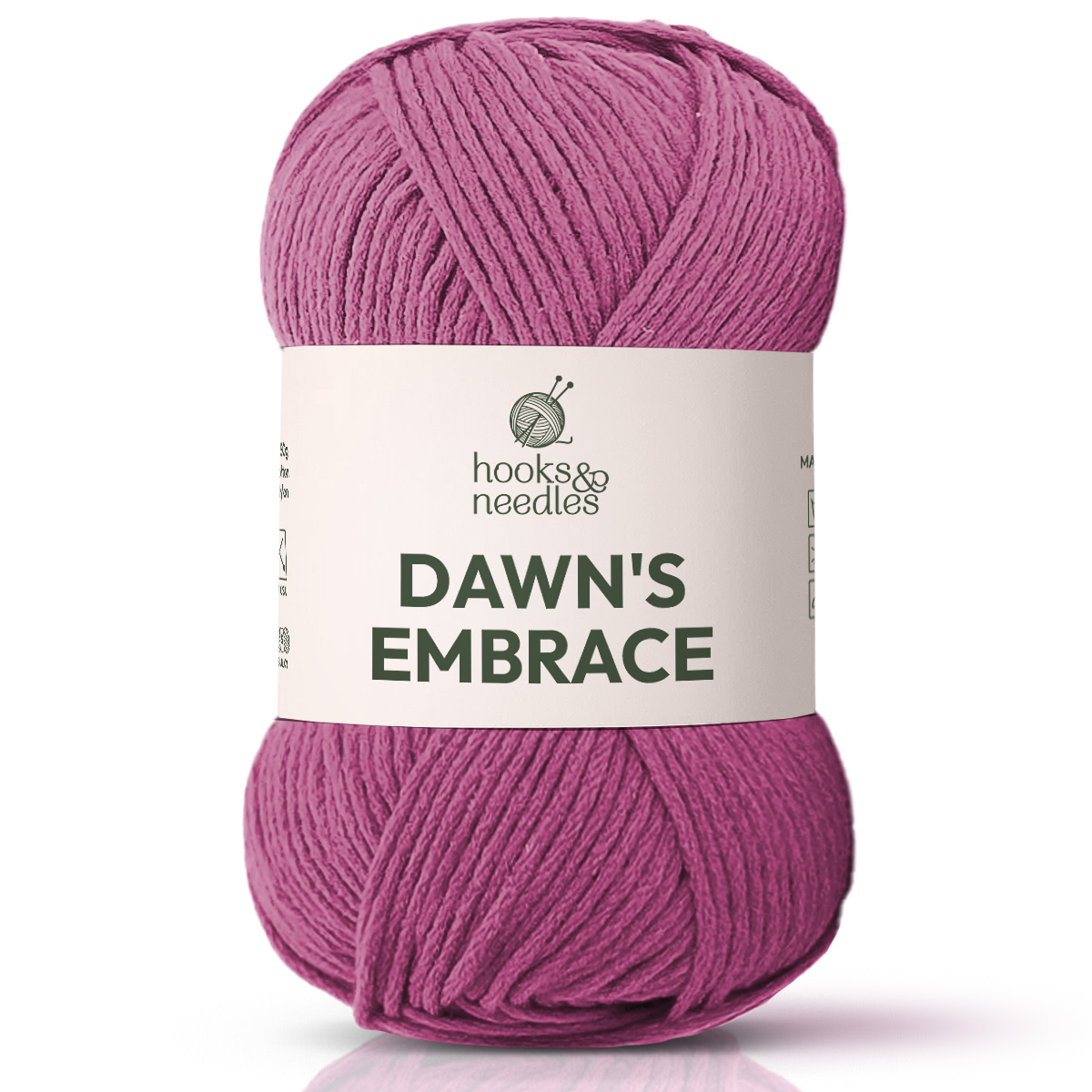 A skein of "Dawn's Embrace Yarn" by Hooks & Needles, in bulky pink with a white label, is perfect for crafting a cozy blanket.