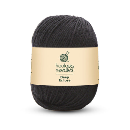 The "Deep Eclipse Yarn 100g" by hooks & needles is a medium-weight, 100% wool skein in a rich black color, making it ideal for creating cozy projects that endure over time.