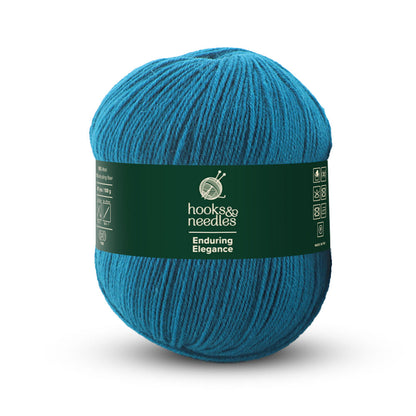 A teal ball of fine-weight yarn featuring a green label that reads "Enduring Elegance" and "hook & needles," offering an anti-pilling wool experience.