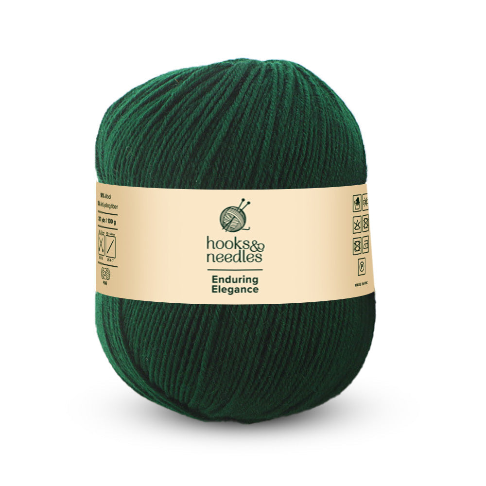 A skein of fine-weight dark green yarn called "Enduring Elegance Yarn 100g" offers unparalleled quality with anti-pilling wool features, including icons for washing instructions.