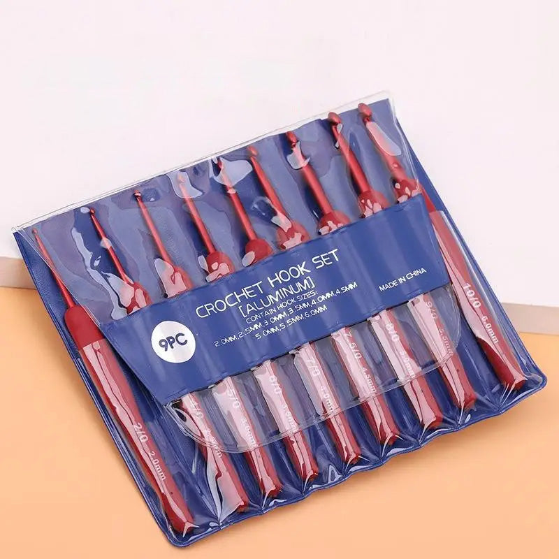 The Ergonomic Crochet Hook Set 9 Pcs with Soft Grip Handles includes nine aluminum hooks in different sizes, all organized in a clear plastic case against a calming blue backdrop for comfortable crocheting.