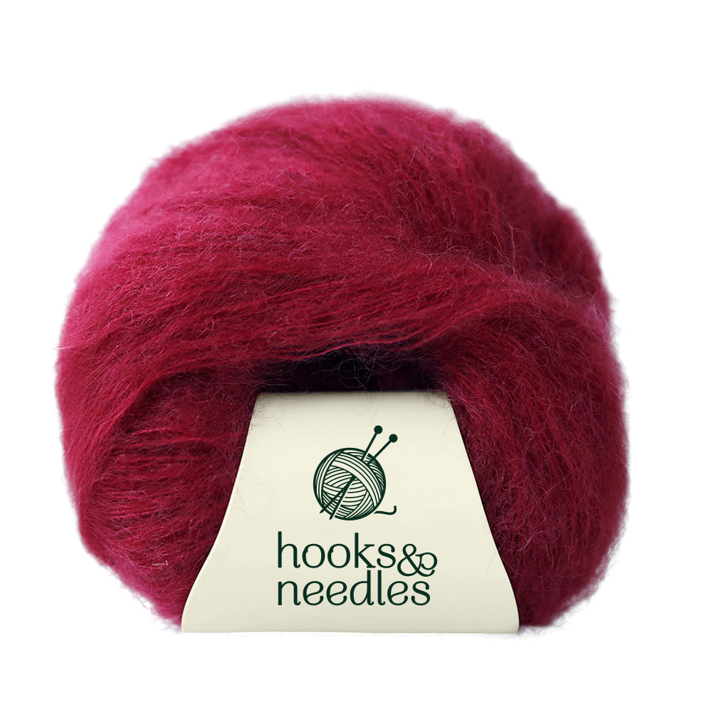 A ball of lace-weight pink yarn branded as "Fusion Finesse Yarn 20g," adorned with a knitting logo and delicately crafted from the finest Merino wool.